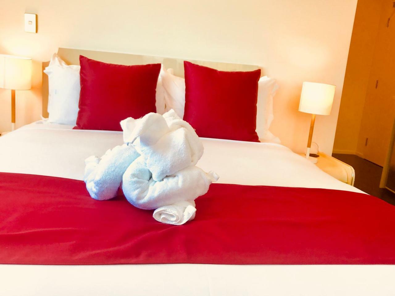 Bealey Plaza Motel Christchurch Dış mekan fotoğraf A bed with a red bed runner